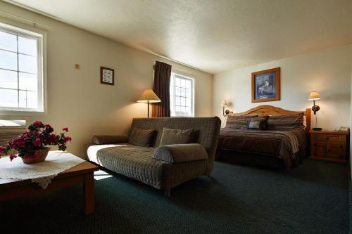 1 dormitorio con 1 cama, 1 sofá y 1 silla en Columbine Inn and Suites en Leadville