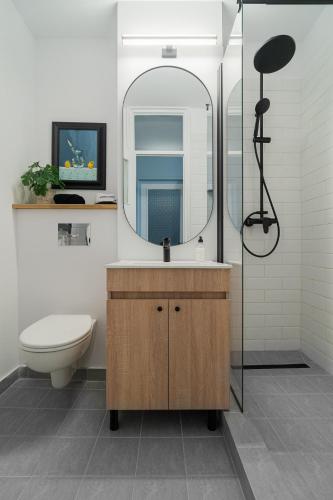 a bathroom with a sink and a mirror and a toilet at Cozy Urban Studio Piata Victoriei in Floreasca