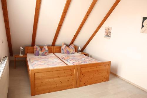 a bedroom with a wooden bed in a attic at Ferienhaus Gleissbuck in Schönbronn