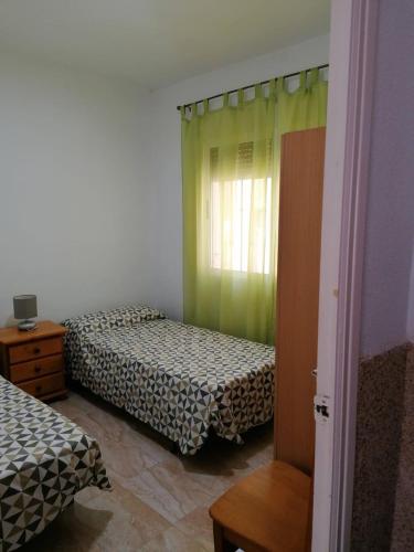 a bedroom with two beds and a window at Mesana playa in Cartagena