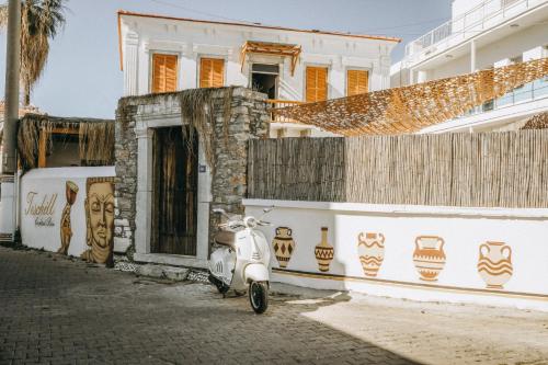 a white scooter parked in front of a building at Notarius Hotel Bodrum in Bodrum City