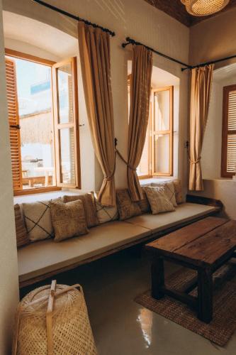 a living room with a bench in front of two windows at Notarius Hotel Bodrum in Bodrum City