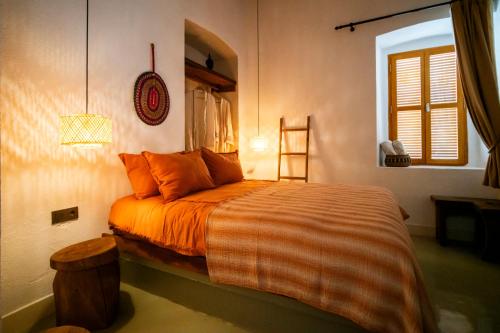 a bedroom with a bed with orange sheets and a window at Notarius Hotel Bodrum in Bodrum City