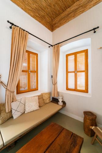 a room with a couch and two windows at Notarius Hotel Bodrum in Bodrum City
