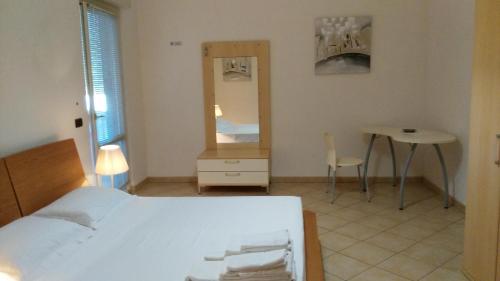 a bedroom with a bed and a table and a mirror at B&B Ore Liete in Martano
