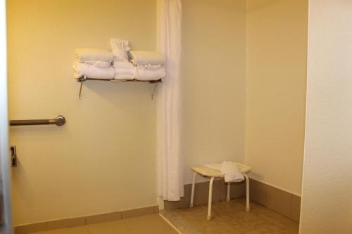 a bathroom with white towels and a stool in a room at Country Inn & Suites by Radisson, Nashville, TN in Nashville