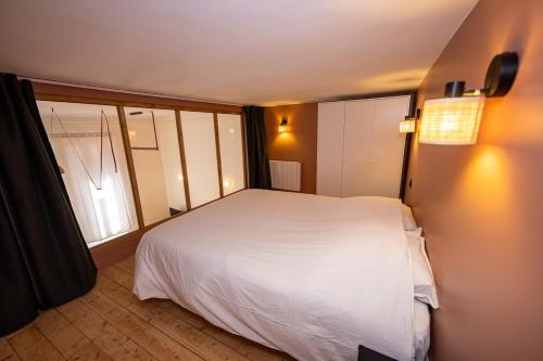 une chambre avec un lit blanc et une fenêtre dans l'établissement Exceptional loft - 2 Bedrooms, à Marseille