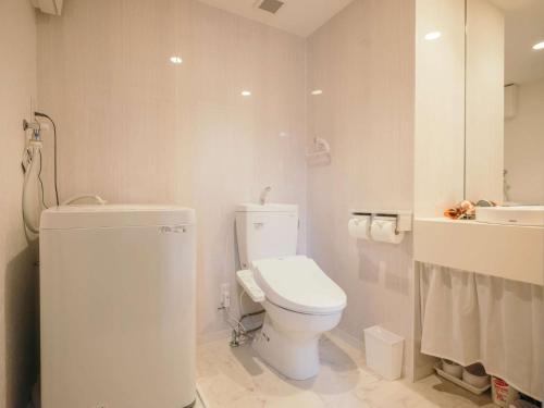 熊本市にあるReqrasサクラマチのトイレと洗面台を備えた白いバスルーム