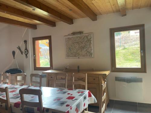une cuisine avec une table et des chaises dans une pièce dans l'établissement Gîte du roy, à Taninges