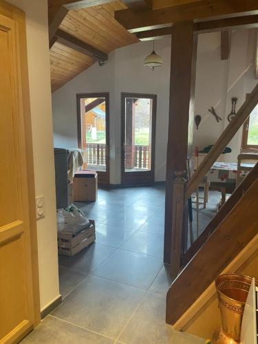 un salon avec un escalier et une pièce avec une table dans l'établissement Gîte du roy, à Taninges