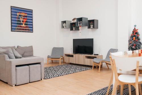 a living room with a christmas tree and a television at Guest House T4 no Porto in Porto