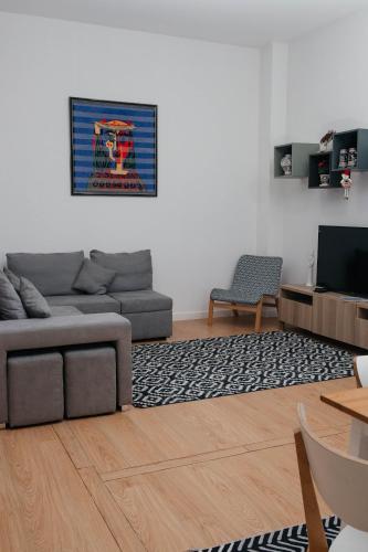a living room with a couch and a tv at Guest House T4 no Porto in Porto