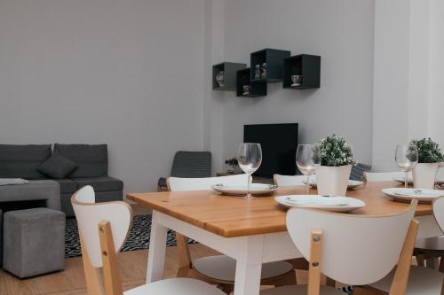 a dining room with a wooden table and white chairs at Guest House T4 no Porto in Porto