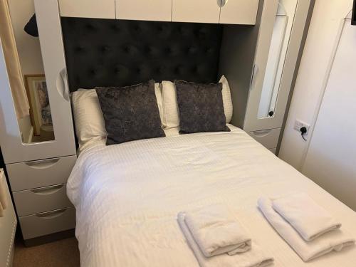 a bedroom with a large bed with towels on it at Harbour Penthouse Whitby in Whitby