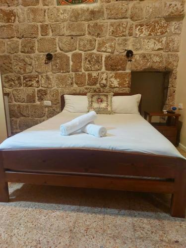 a bed in a room with a brick wall at Hebi house in ‘Akko