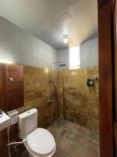 a bathroom with a toilet and a shower at Kanugrahan Umah Kebun in Bedugul