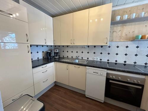 a kitchen with white cabinets and a sink at Chalet 1480 in Gaschurn