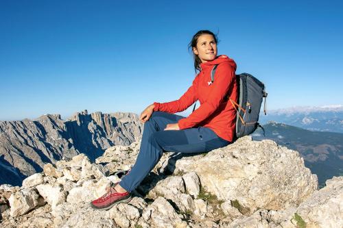 a woman sitting on the top of a mountain at Hotel Dosses in Tires