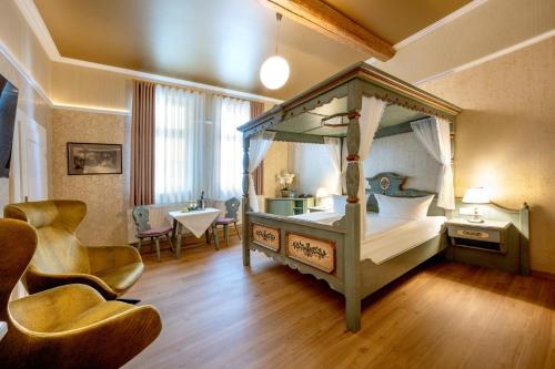 a bedroom with a canopy bed and a table and chairs at Schwarzer Bär Jena in Jena