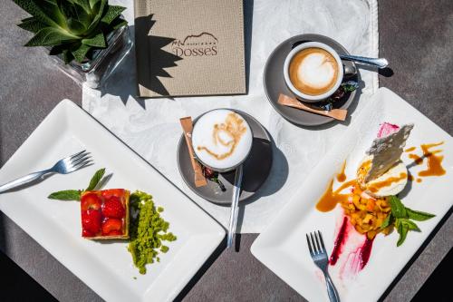 a table with two plates of food and a cup of coffee at Hotel Dosses in Tires