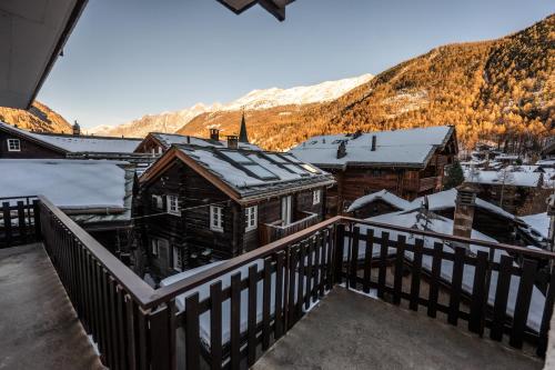 a balcony of a house with snow on the roof at Chalet Aroleid Zermatt by Inspiringplaces Zermatt in Zermatt