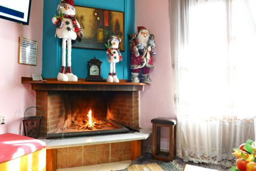 a living room with a fireplace with christmas decorations at Patriko in Arachova