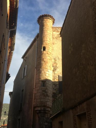 a building with a brick tower on the side of it at Les Remparts in Caudiès-de-Fenouillèdes