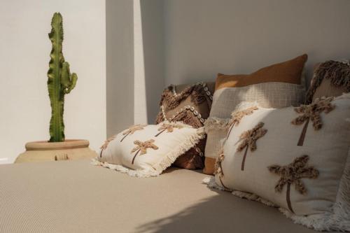 a couch with pillows and a cactus on it at Midi Pool Villa & SPA in Veglie