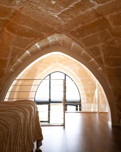 a room with an archway with a bed and a window at Midi Pool Villa & SPA in Veglie
