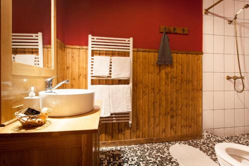 uma casa de banho com um lavatório, um WC e paredes vermelhas em Valea Verde Retreat Transilvania em Cund
