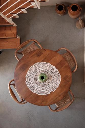 a wooden table with two chairs around it at Midi Pool Villa & SPA in Veglie