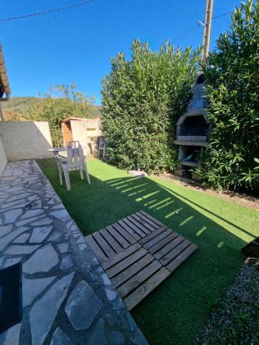 une pelouse avec une table et une chaise dans une cour dans l'établissement Joli F2 avec jolie terrasse -Appt4, à Amélie-les-Bains-Palalda