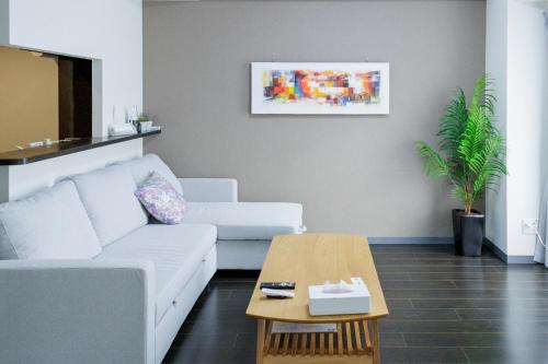 a living room with a white couch and a coffee table at Bowking House Omotesando in Sapporo