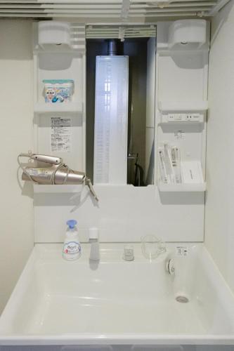 a bathroom with a sink and a mirror at Bowking House Omotesando in Sapporo
