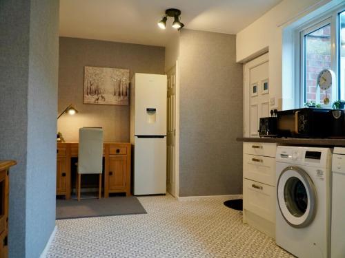 a kitchen with a washer and a white refrigerator at Deal House in Stockton-on-Tees