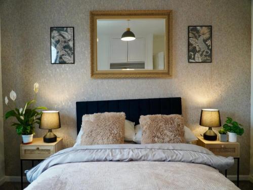 a bedroom with a bed with a mirror and two lamps at Deal House in Stockton-on-Tees