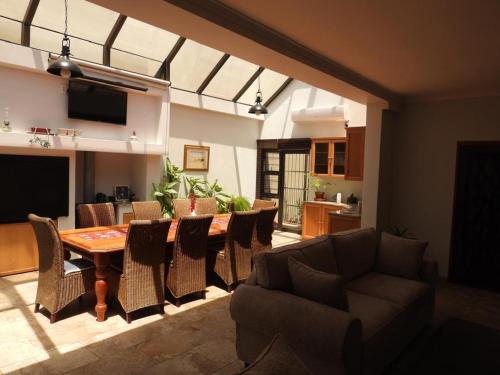 a living room with a wooden table and chairs at The Shifting Whispering Sands Guesthouse in Walvis Bay