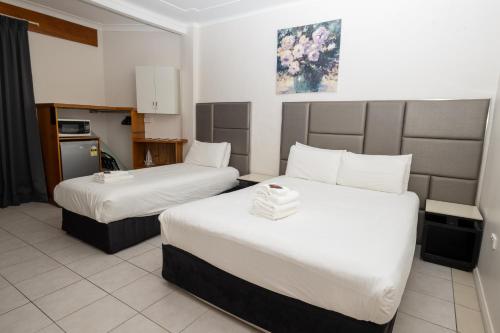 a hotel room with two beds and a kitchen at Gosford Inn Motel in Gosford