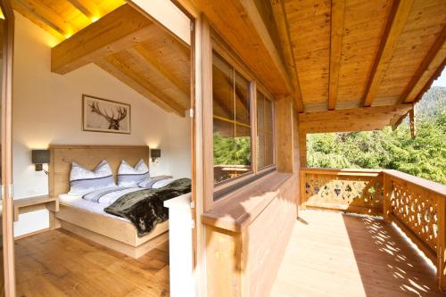 a bedroom in a house with a bed on a balcony at Superior Chalet Tiroler Madl in Achenkirch