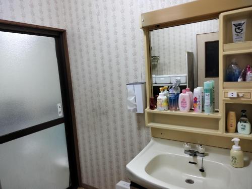 a bathroom with a sink and a mirror at Guesthouse Naruto Ohenro ゲストハウス鳴門 おへんろ in Naruto