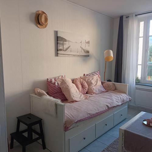 un lit avec des oreillers dessus dans une chambre dans l'établissement Le petit nid de Katia, à Bernières-sur-Mer