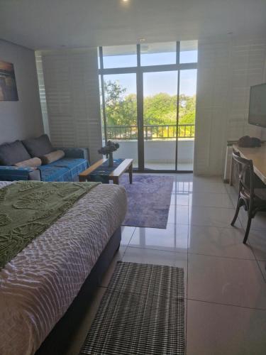 a bedroom with a bed and a living room at Breakers Resort, Umhlanga, 232 in Durban
