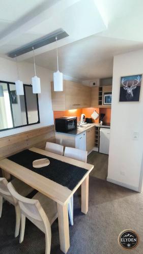 une cuisine et une salle à manger avec une table et des chaises dans l'établissement Appartement Les Gémeaux - La Plagne - Belle Plagne, à La Plagne Tarentaise