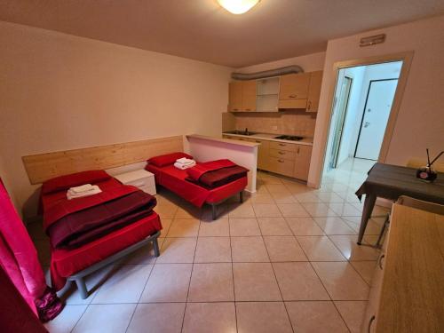 a room with two red chairs and a kitchen at Casa vacanze 7 in Pescincanna