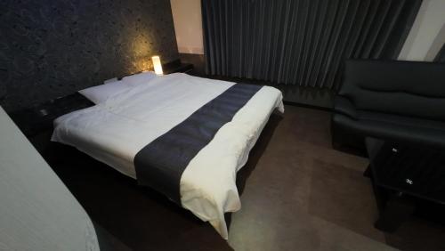 a bed in a hotel room with a candle on it at ブルーエール in Nobeoka