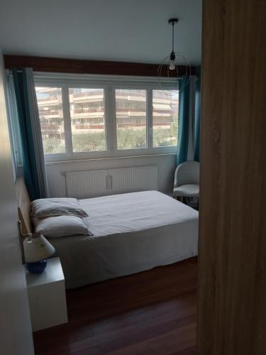 une chambre avec un lit et une grande fenêtre dans l'établissement Appartement avec vue mer à Antibes, à Antibes