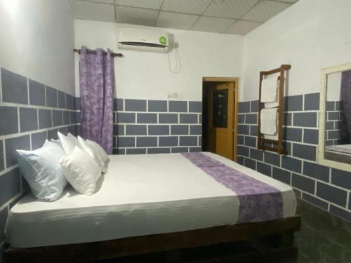 a bedroom with a bed with blue tiled walls at Edy's Nest in Dambulla