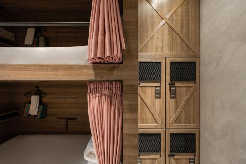 a bedroom with wooden cabinets and a bed with a curtain at Hotel Leisure 台南行旅-巷弄潮旅 in Tainan