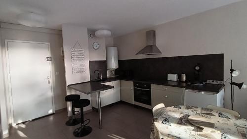 - une cuisine avec un comptoir et une table dans une pièce dans l'établissement L'Ostréa T2 avec piscine et parking face plage, à Andernos-les-Bains