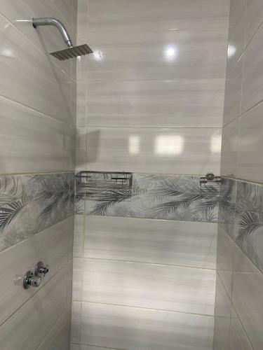 a bathroom with a shower with a glass door at Bennyz Guest House in Pretoria